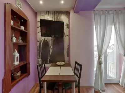 a dining room with a table and a tv on a wall at Beauty of Krakow Studio in Kraków