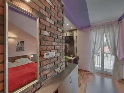 a bedroom with a brick wall and a mirror at Beauty of Krakow Studio in Kraków