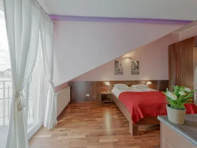 a bedroom with a red bed and a large window at Beauty of Krakow Studio in Kraków