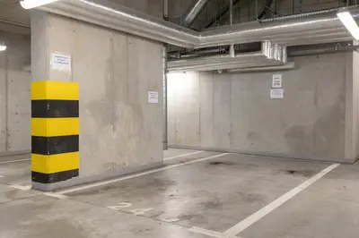an empty parking garage with a yellow and black pole at Osiedle Avia Harmonious Apartment with Balcony Cracow by Renters Prestige in Kraków