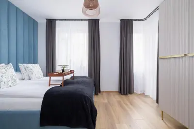 a bedroom with a bed with a table and a window at Osiedle Avia Harmonious Apartment with Balcony Cracow by Renters Prestige in Kraków