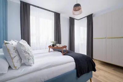 a bedroom with a large bed with a table on it at Osiedle Avia Harmonious Apartment with Balcony Cracow by Renters Prestige in Kraków
