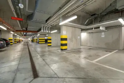 an empty parking garage with yellow and black stripes at Osiedle Avia Harmonious Apartment with Balcony Cracow by Renters Prestige in Kraków