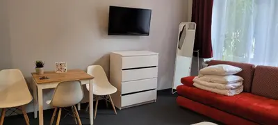 a small living room with a red couch and a table at TLC Apartments Cracow in Kraków