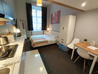 a small room with a bed and a kitchen at TLC Apartments Cracow in Kraków