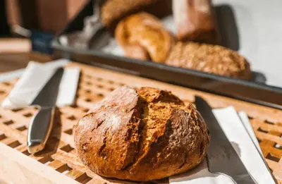 a loaf of bread sitting on a table with a knife at MEININGER Kraków Centrum in Kraków