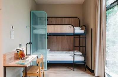 a small room with bunk beds and a desk at MEININGER Kraków Centrum in Kraków