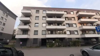 a large white building with balconies in a parking lot at Mini Apartament Kraków PN / Cracow NORTH z parkingiem in Kraków