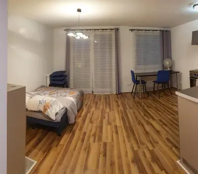 a bedroom with a bed and a table and chairs at Mini Apartament Kraków PN / Cracow NORTH z parkingiem in Kraków