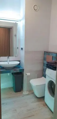 a bathroom with a sink and a washing machine at Mini Apartament Kraków PN / Cracow NORTH z parkingiem in Kraków