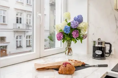 a vase of flowers sitting on a counter next to a window at Premium apartment in Parisian style in the heart of Old Krakow in Kraków