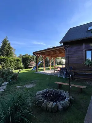 a fire pit in a yard next to a cabin at Domek do wynajęcia in Poręba Wielka
