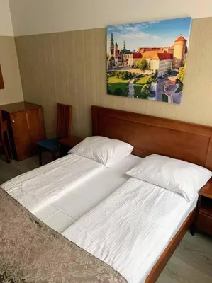 two beds in a room with a painting on the wall at Great apartment in the Old Town in Kraków