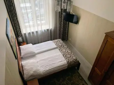 a small bed in a room with a window at Great apartment in the Old Town in Kraków