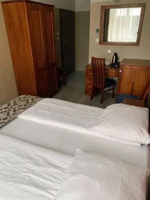 two beds in a hotel room with a desk and a desk at Great apartment in the Old Town in Kraków