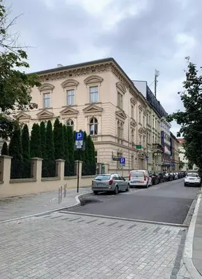 a street with cars parked in front of a building at Great apartment in the Old Town in Kraków