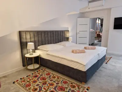 a bedroom with a large bed and a rug at Juwel Apartments Kraków z widokiem na Wawel ap 47 in Kraków