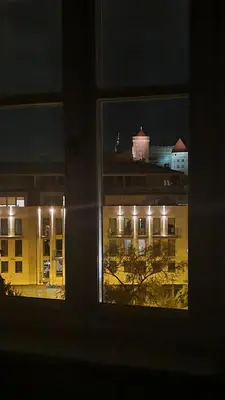 a view of a building from a window at night at Juwel Apartments Kraków z widokiem na Wawel ap 47 in Kraków