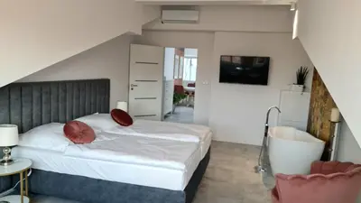a bedroom with a bed and a tv and a staircase at Juwel Apartments Kraków z widokiem na Wawel ap 47 in Kraków