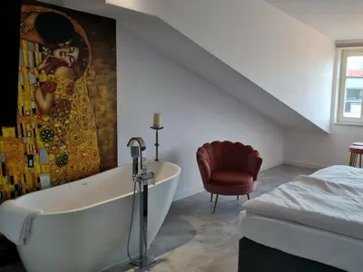 a bathroom with a bath tub and a painting on the wall at Juwel Apartments Kraków z widokiem na Wawel ap 47 in Kraków