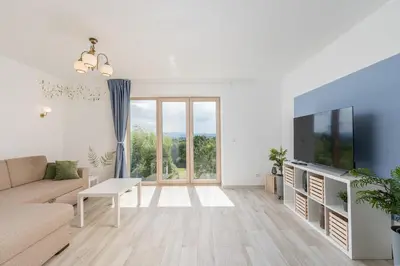 a living room with a couch and a tv at Dom pod Lipą in Łyczanka