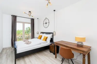 a bedroom with a bed and a desk at Dom pod Lipą in Łyczanka