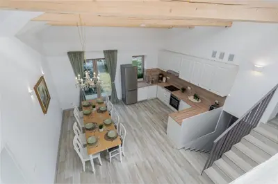 a kitchen and dining room with a table and chairs at Dom pod Lipą in Łyczanka