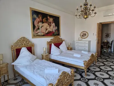 a bedroom with two beds and a painting on the wall at Juwel Apartments Kraków z widokiem na Wawel ap 29A in Kraków
