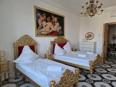 a bedroom with two beds and a painting on the wall at Juwel Apartments Kraków z widokiem na Wawel ap 29A in Kraków