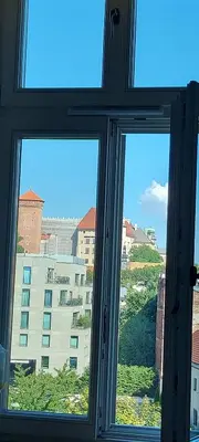 a window with a view of a building at Juwel Apartments Kraków z widokiem na Wawel ap 29A in Kraków