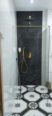 a bathroom with a shower with a black wall at Juwel Apartments Kraków z widokiem na Wawel ap 29A in Kraków