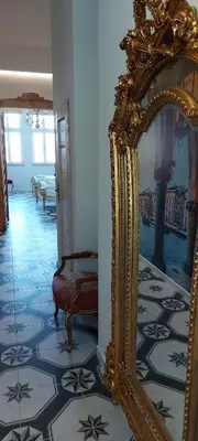 a gold mirror on the floor of a hallway at Juwel Apartments Kraków z widokiem na Wawel ap 29A in Kraków