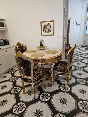 a dining room with a table and chairs on a tile floor at Juwel Apartments Kraków z widokiem na Wawel ap 29A in Kraków