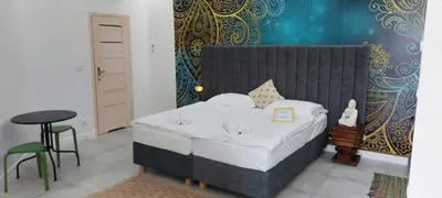 a bedroom with a bed and a table and a stool at JUWEL Apartments Kraków Indyjski ap 29 in Kraków