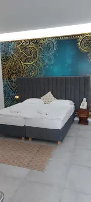 a large bed in a room with a wall at JUWEL Apartments Kraków Indyjski ap 29 in Kraków