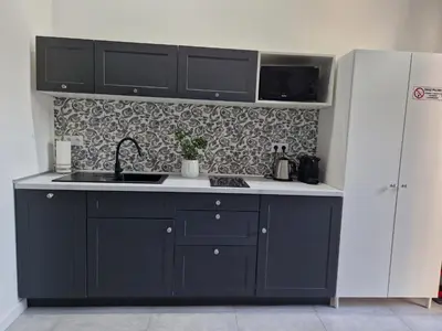a kitchen with black cabinets and a sink at JUWEL Apartments Kraków Indyjski ap 29 in Kraków