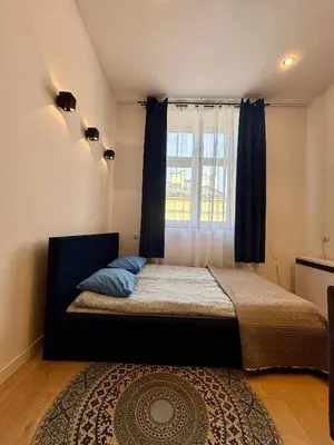 a bedroom with a bed with a window and a rug at Vintage Senacka 9/7 Apartment in Kraków