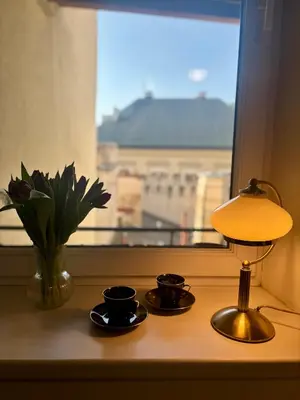 a table with two cups and a lamp and a window at Vintage Senacka 9/7 Apartment in Kraków