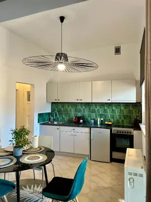 a kitchen with white cabinets and a table with chairs at Vintage Senacka 9/7 Apartment in Kraków