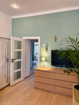 a living room with a flat screen tv on a dresser at Vintage Senacka 9/7 Apartment in Kraków