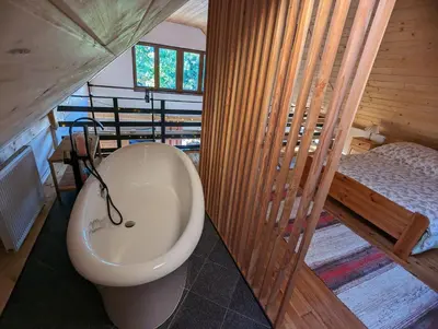 a bathroom with a toilet and a bed in a room at Makowy domek in Maków Podhalański