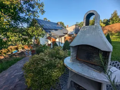 a stone oven sitting in a yard with a house at Makowy domek in Maków Podhalański