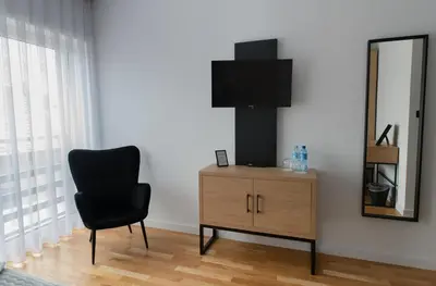 a black chair sitting next to a dresser with a mirror at Apartamenty Loftove in Wadowice