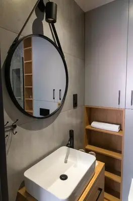 a bathroom with a white sink and a mirror at Apartamenty Loftove in Wadowice