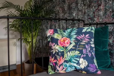 a pillow sitting on a bed next to a plant at Apartament tuż przy Wawelu in Kraków