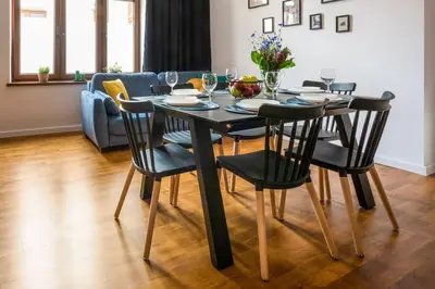 a black dining room table with black chairs in a living room at Apartament tuż przy Wawelu in Kraków