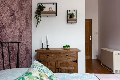 a bedroom with a bed and a dresser with plants on it at Apartament tuż przy Wawelu in Kraków