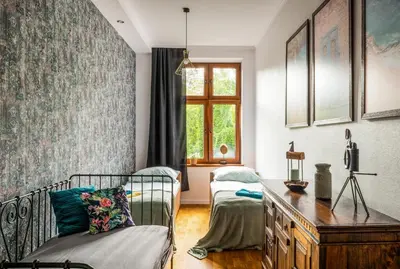 a bedroom with a bed and a desk and a window at Apartament tuż przy Wawelu in Kraków