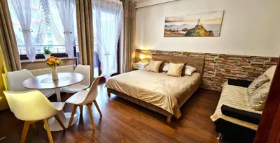 a bedroom with a bed and a table in a room at Modern Apartment SANDY BEACH down town, aquapark, free parking in Kraków