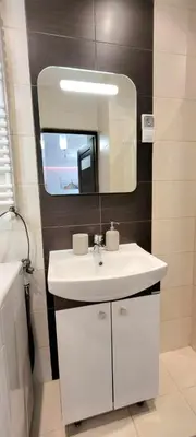 a bathroom with a white sink and a mirror at Modern Apartment SANDY BEACH down town, aquapark, free parking in Kraków